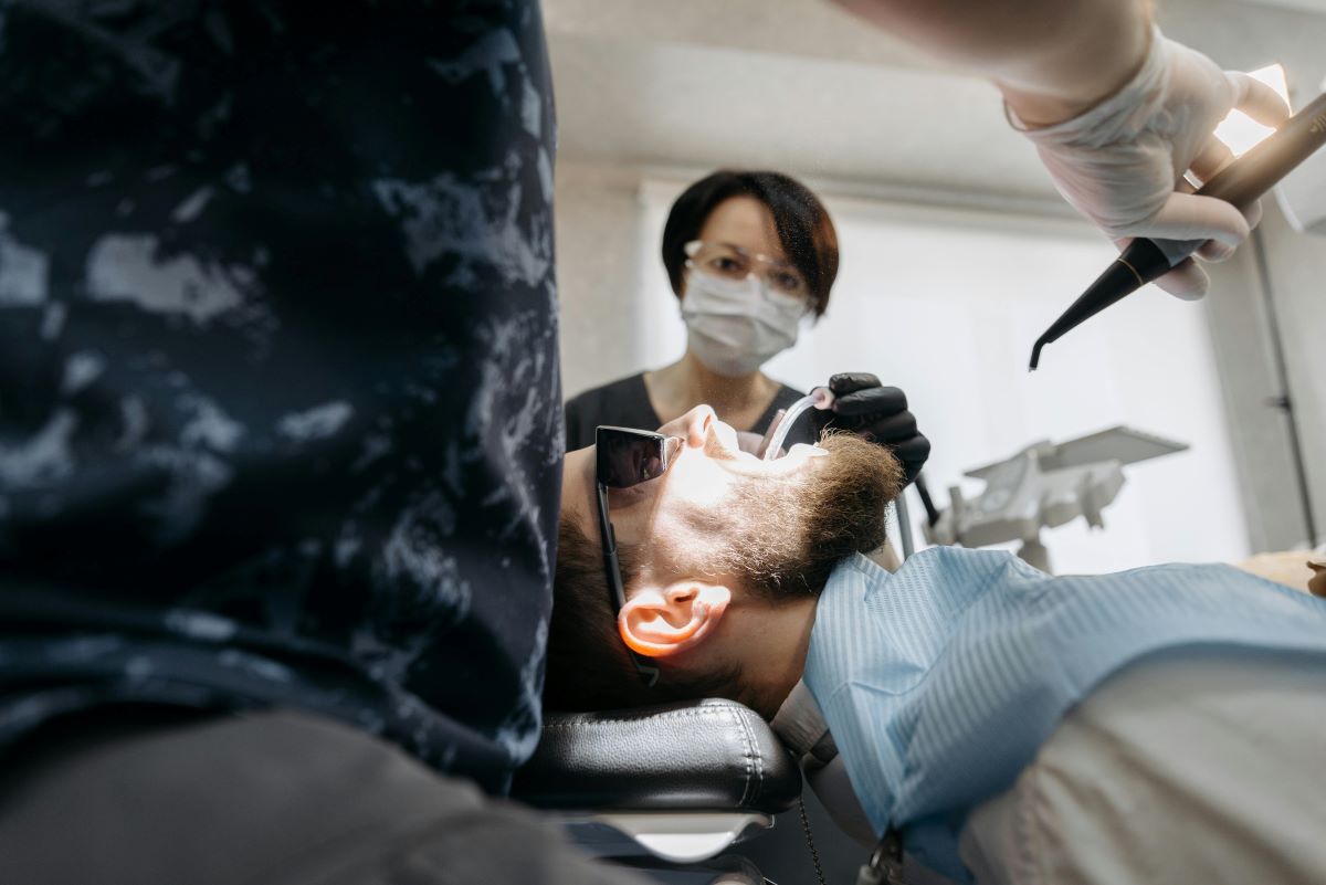 Teeth Cleaning in Milton Procedure at White Dove Dental Dental hygienist performing teeth cleaning in Milton on a patient with protective eyewear